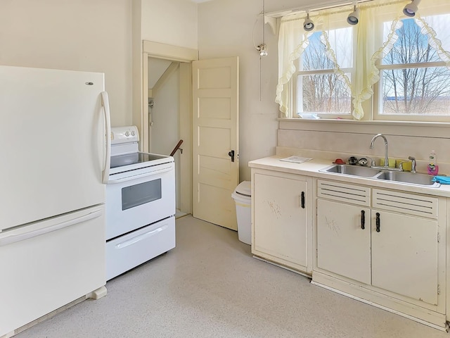 kitchen featuring white cabinets, white appliances, light countertops, and a sink