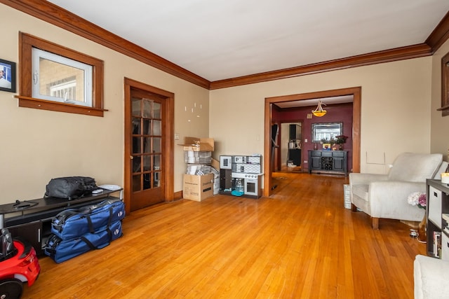 living area with ornamental molding and wood finished floors