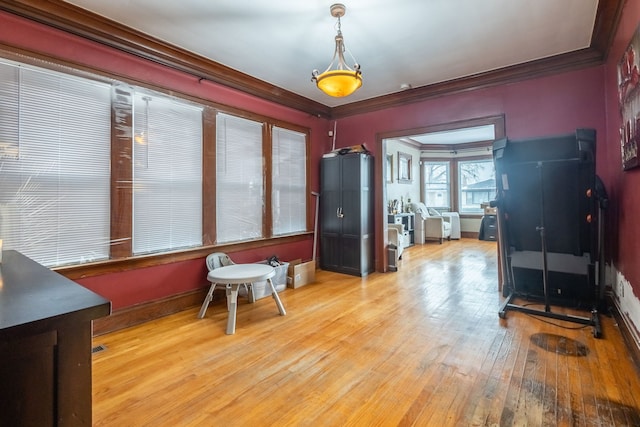 dining area featuring hardwood / wood-style flooring, baseboards, and crown molding