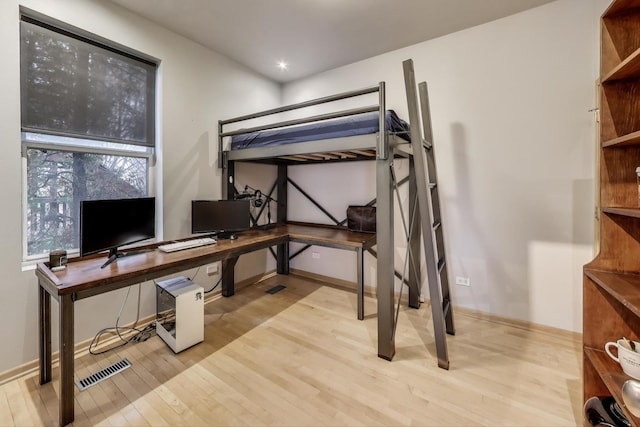 bedroom featuring visible vents, baseboards, and wood finished floors