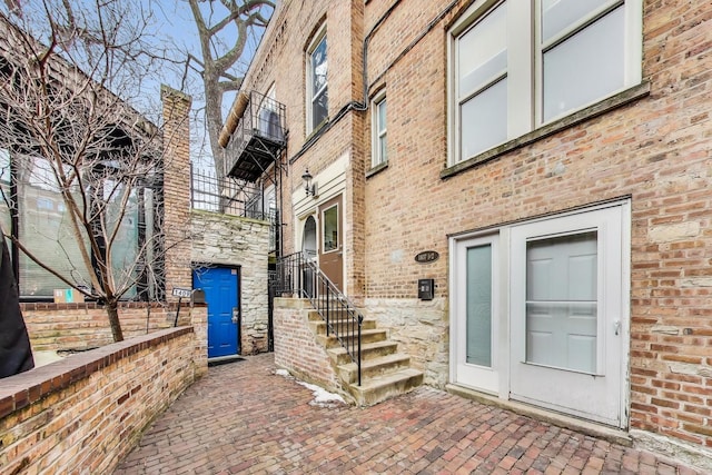 property entrance with stone siding and brick siding