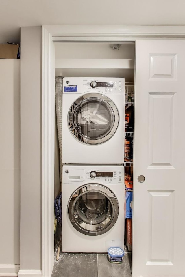 clothes washing area with laundry area and stacked washer and clothes dryer