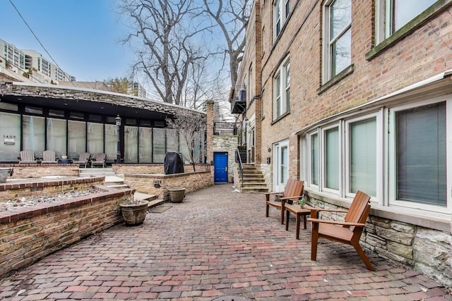 view of patio with a grill and stairway