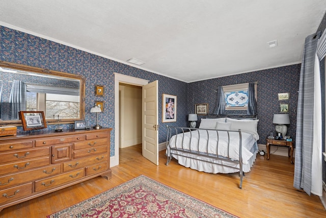 bedroom featuring baseboards, wallpapered walls, ornamental molding, visible vents, and light wood finished floors