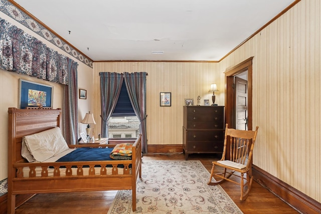 bedroom featuring ornamental molding, baseboards, and wood finished floors