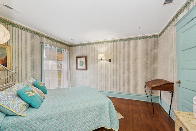 bedroom featuring crown molding, visible vents, wood finished floors, and wallpapered walls