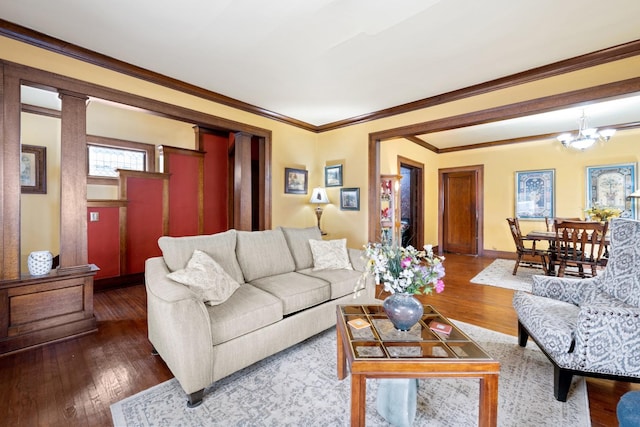 living room featuring a chandelier, crown molding, wood finished floors, and baseboards