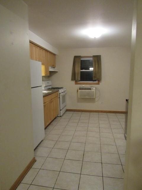 kitchen with white appliances, under cabinet range hood, baseboards, and an AC wall unit