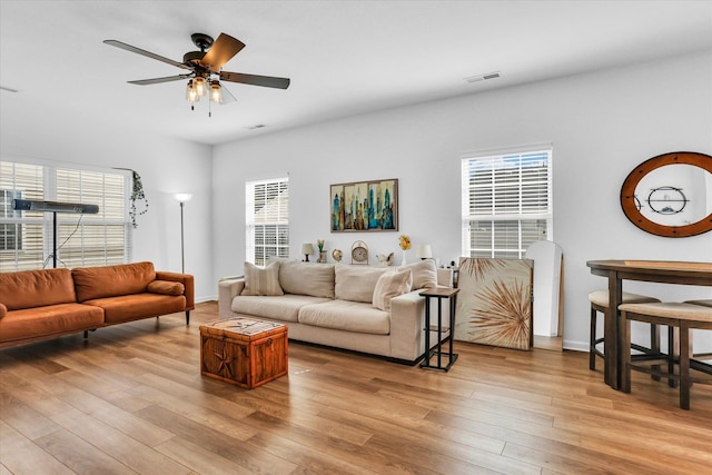 living room with visible vents, baseboards, ceiling fan, and wood finished floors