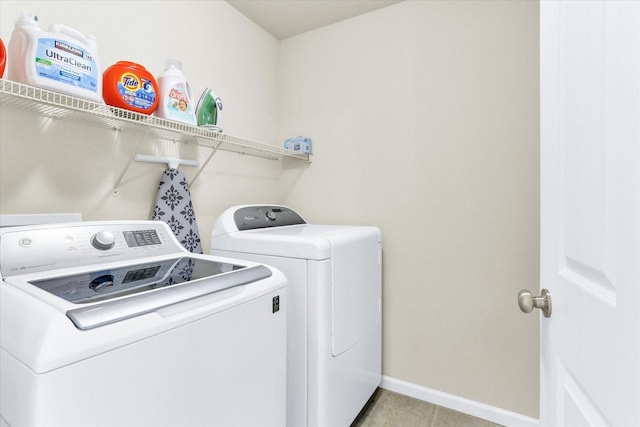 laundry room with light tile patterned floors, baseboards, laundry area, and washer and clothes dryer