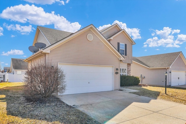 view of front of home featuring fence, a garage, and driveway