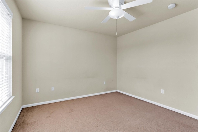 spare room featuring carpet flooring, a ceiling fan, and baseboards