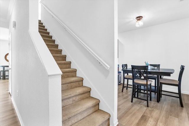 stairs featuring wood finished floors and baseboards