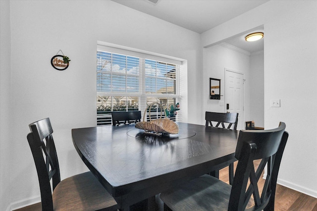 dining room featuring ornamental molding, baseboards, and dark wood-style flooring