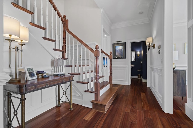 entrance foyer with ornamental molding, stairway, and wood finished floors