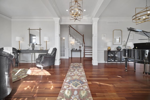 entrance foyer featuring visible vents, a notable chandelier, and ornate columns