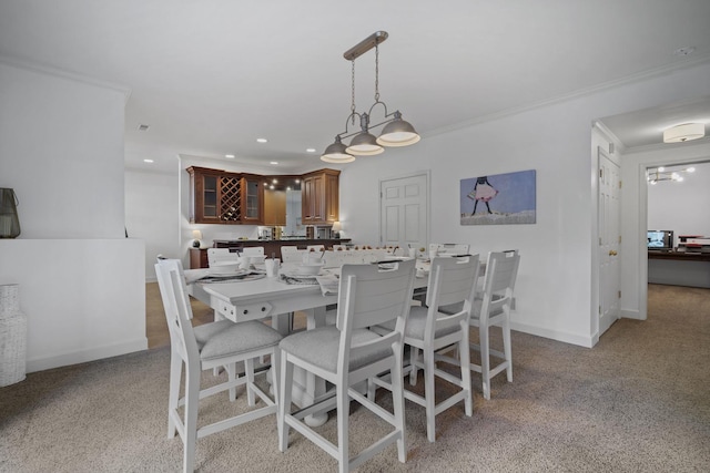 dining room featuring baseboards, ornamental molding, light carpet, and recessed lighting