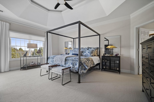 carpeted bedroom with baseboards, a tray ceiling, a ceiling fan, and crown molding