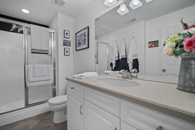 bathroom featuring toilet, a shower stall, visible vents, and tile patterned floors