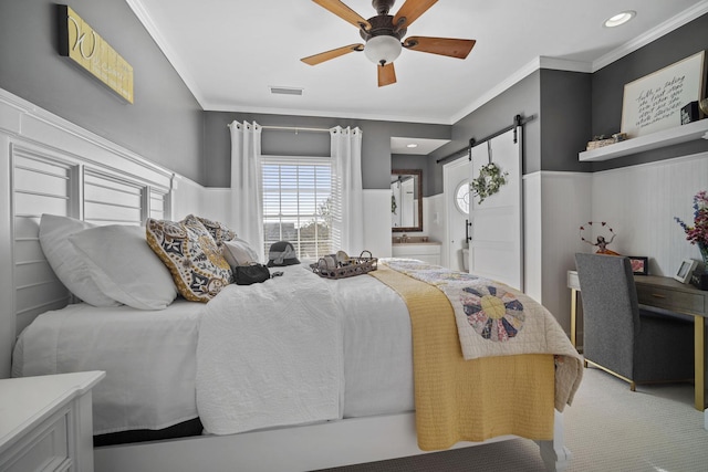 bedroom with a barn door, visible vents, ceiling fan, and ornamental molding