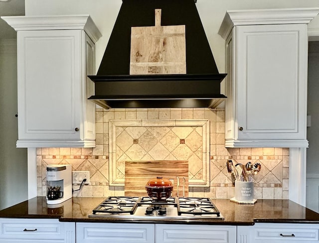 kitchen featuring white cabinetry, wall chimney exhaust hood, stainless steel gas cooktop, and decorative backsplash