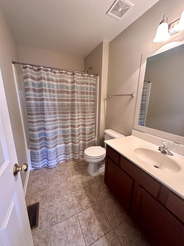 bathroom with toilet, vanity, visible vents, and tile patterned floors