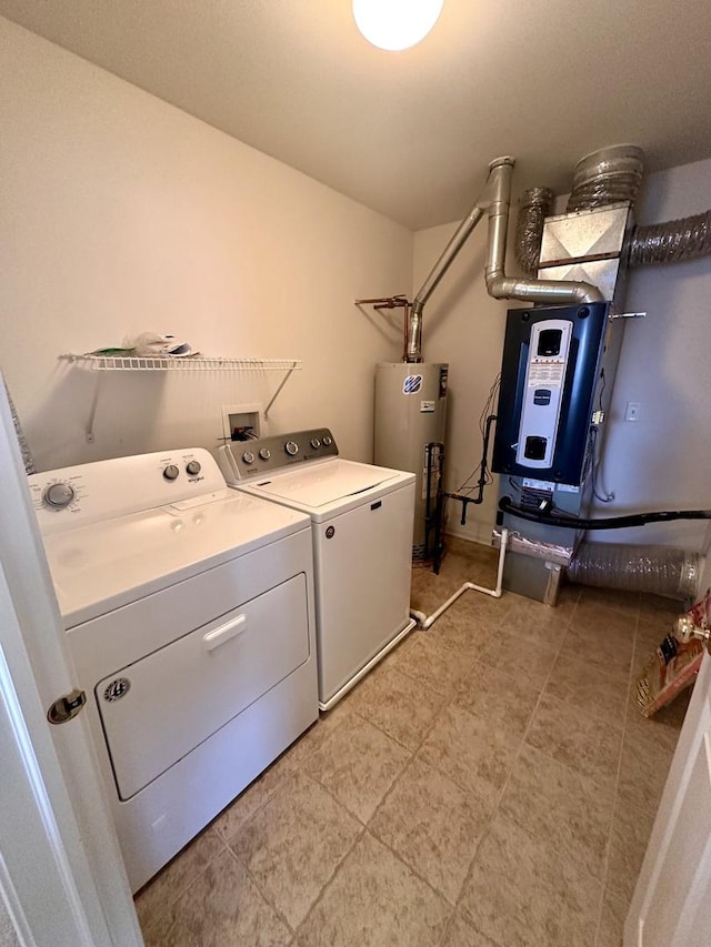 clothes washing area featuring washing machine and dryer, laundry area, and water heater