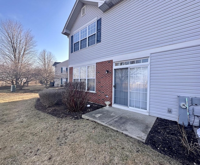 back of property featuring brick siding and a lawn