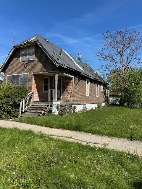 304 W 104th Pl, Chicago, IL 60628 - view of side of property with brick siding, covered porch, and a yard