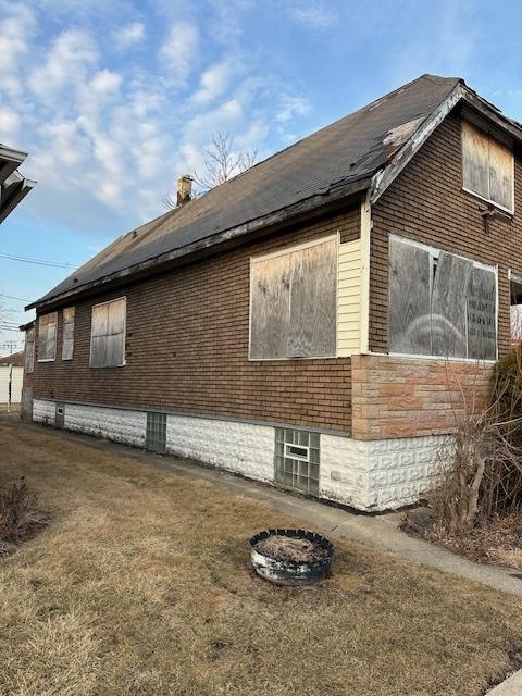 view of side of home with brick siding and a chimney