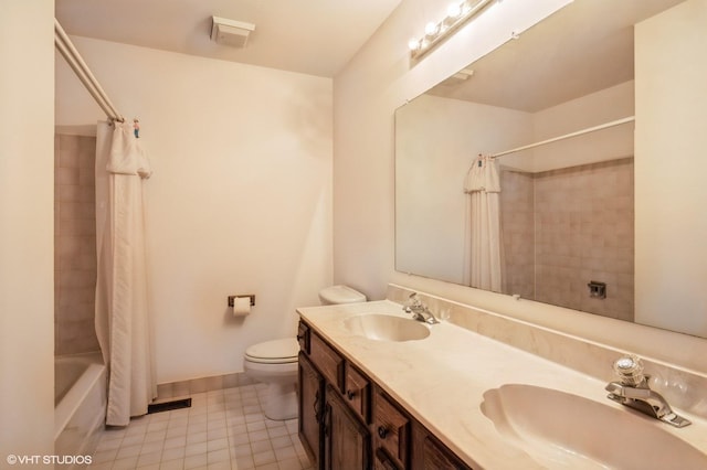 bathroom featuring a sink, shower / bath combo with shower curtain, toilet, and tile patterned floors