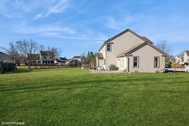 back of property with a yard, a patio, and fence