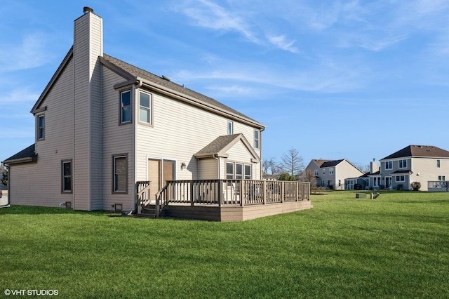 back of house featuring a deck, a yard, and a chimney