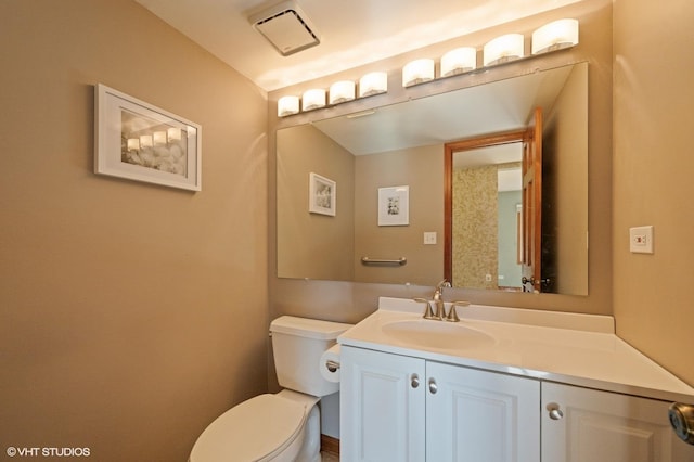 bathroom with vanity, toilet, and visible vents