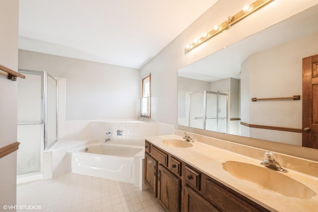 bathroom with double vanity, a stall shower, a garden tub, and a sink