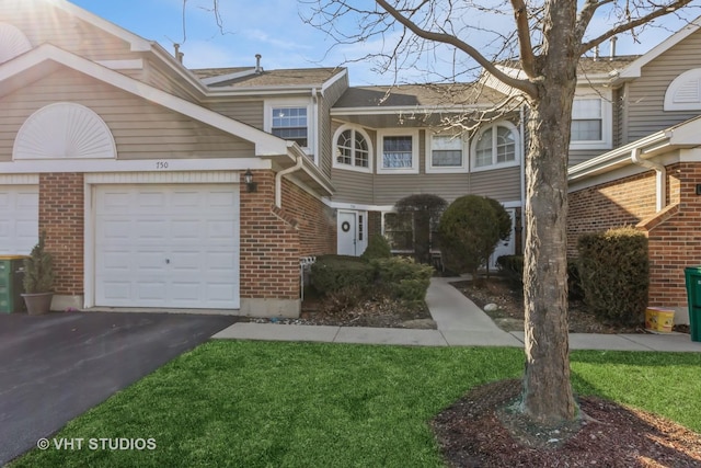 townhome / multi-family property with aphalt driveway, an attached garage, and brick siding