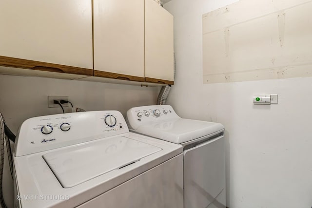 laundry room with separate washer and dryer and cabinet space