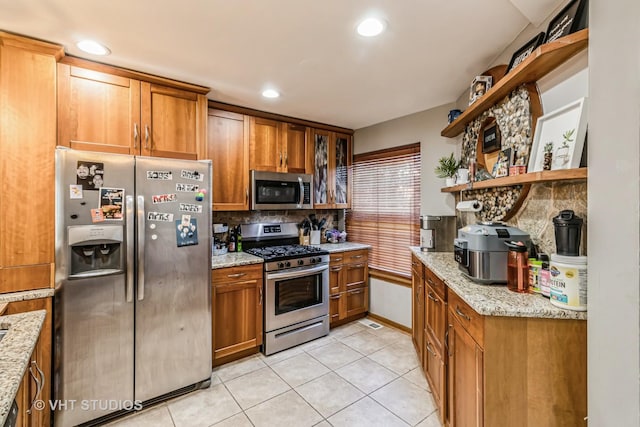 kitchen with brown cabinetry, light tile patterned flooring, stainless steel appliances, and open shelves