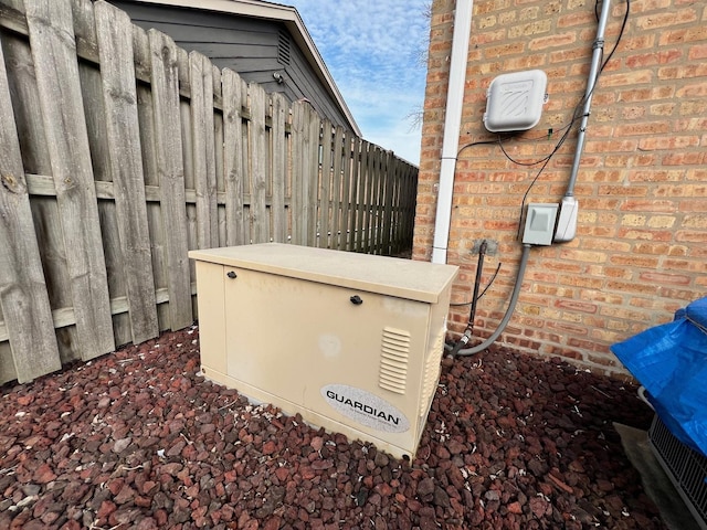 details with fence, a power unit, and brick siding