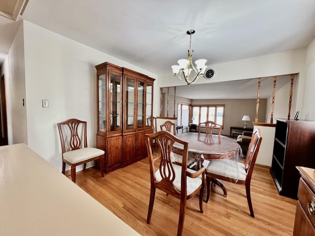 dining space featuring light wood-style flooring and a notable chandelier