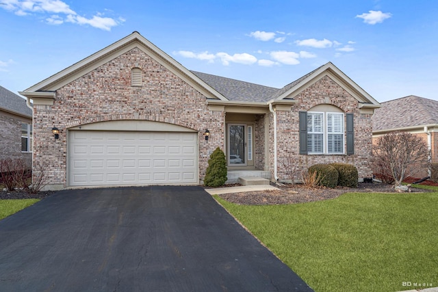 ranch-style house with a garage, a front lawn, brick siding, and aphalt driveway