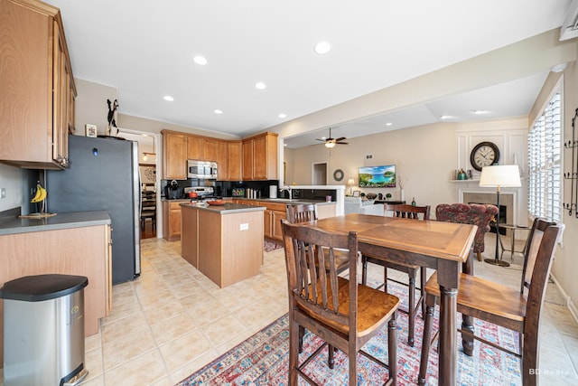 kitchen featuring a center island, light tile patterned floors, stainless steel appliances, recessed lighting, and ceiling fan