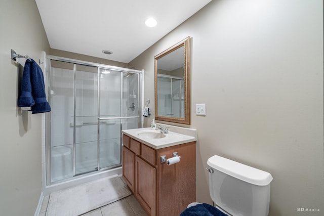 bathroom featuring a stall shower, tile patterned flooring, vanity, and toilet