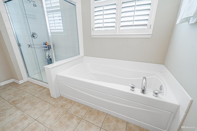 full bathroom featuring a garden tub, a shower stall, and tile patterned floors