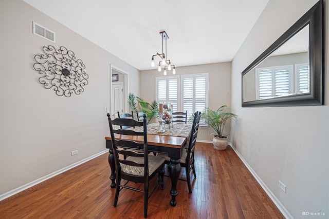 dining area with hardwood / wood-style flooring, baseboards, visible vents, and a chandelier