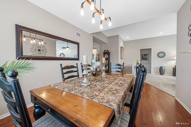 dining space with a ceiling fan, baseboards, visible vents, and hardwood / wood-style floors