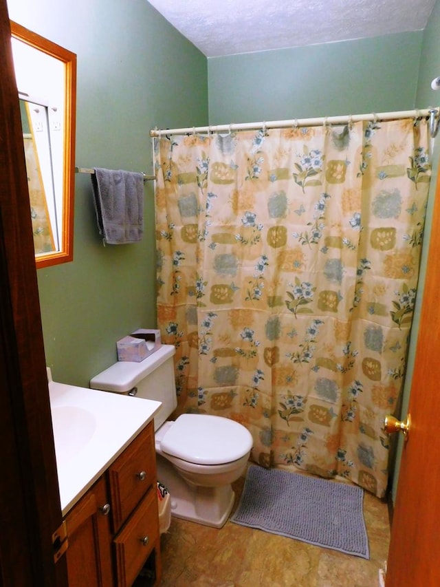 bathroom featuring toilet, a shower with shower curtain, and vanity