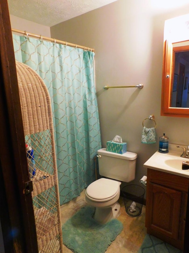 full bathroom with a textured ceiling, a shower with shower curtain, vanity, and toilet