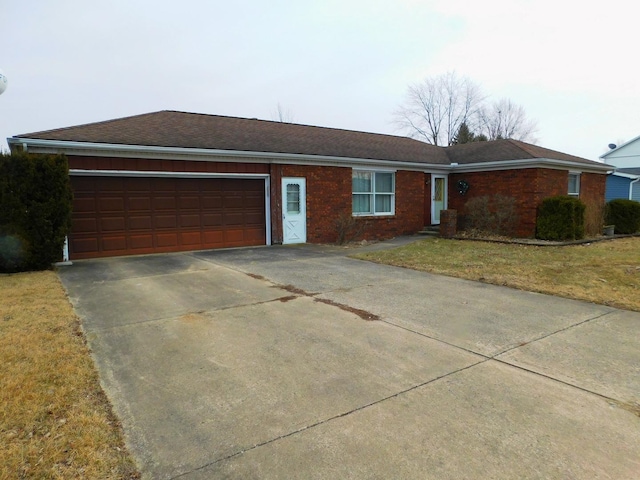 single story home with an attached garage, driveway, a front lawn, and brick siding