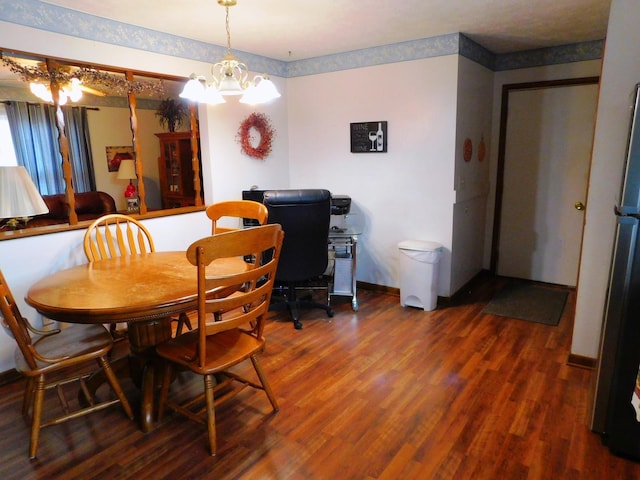 dining space with baseboards, a chandelier, and wood finished floors